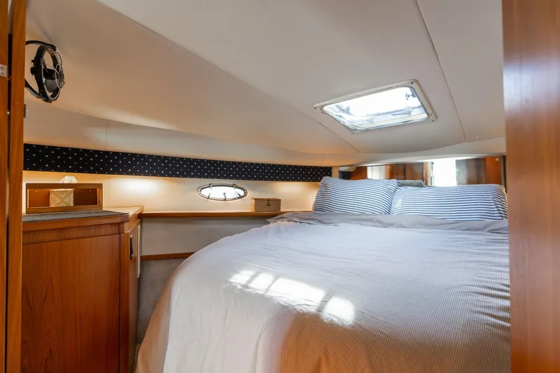 Slide: The Image of Cozy cabin interior of 1998 Tiara Yachts 3500 Express with bed and wooden cabinetry. - 18