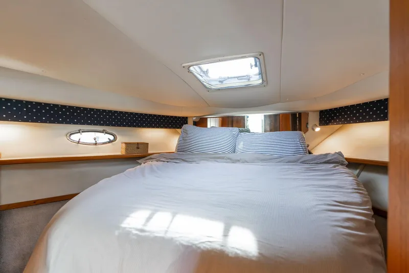 Slide: The Image of Cozy cabin interior of 1998 Tiara Yachts 3500 Express with skylight and striped bedding. - 19