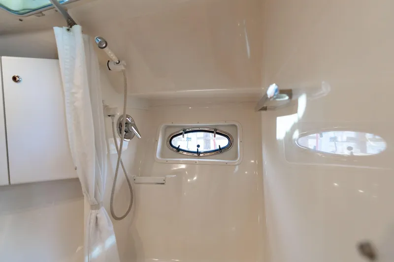 Slide: The Image of 1998 Tiara Yachts 3500 Express bathroom with shower and porthole window. - 23