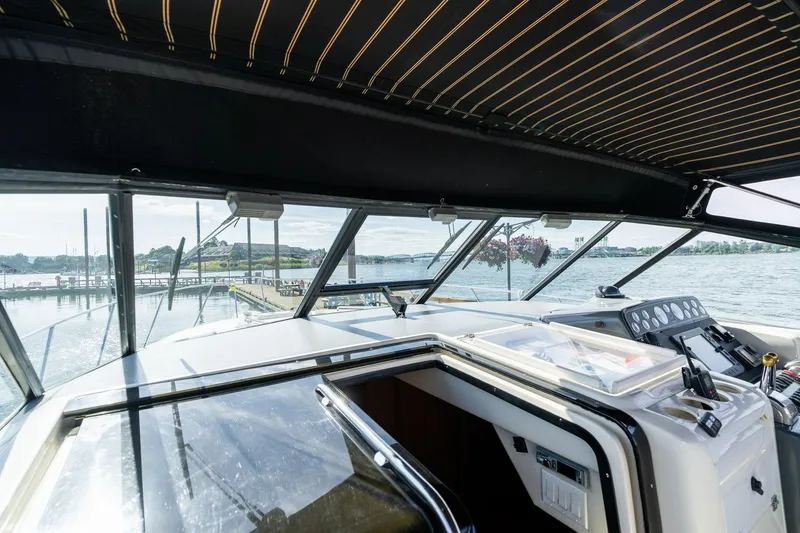 Slide: The Image of 1998 Tiara Yachts 3500 Express cockpit view with marina backdrop. - 27