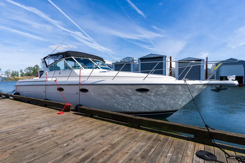 Slide: The Image of 1998 Tiara Yachts 3500 Express docked at marina under clear blue sky. - 3