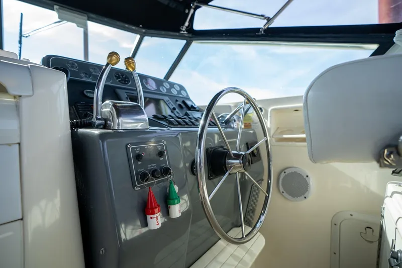 Slide: The Image of Cockpit of a 1998 Tiara Yachts 3500 Express, featuring steering wheel and control panel. - 30