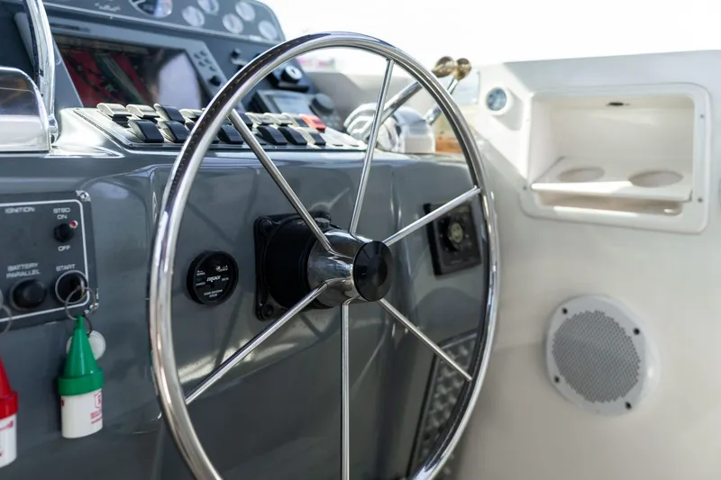 Slide: The Image of Steering wheel and controls of a 1998 Tiara Yachts 3500 Express boat. - 37