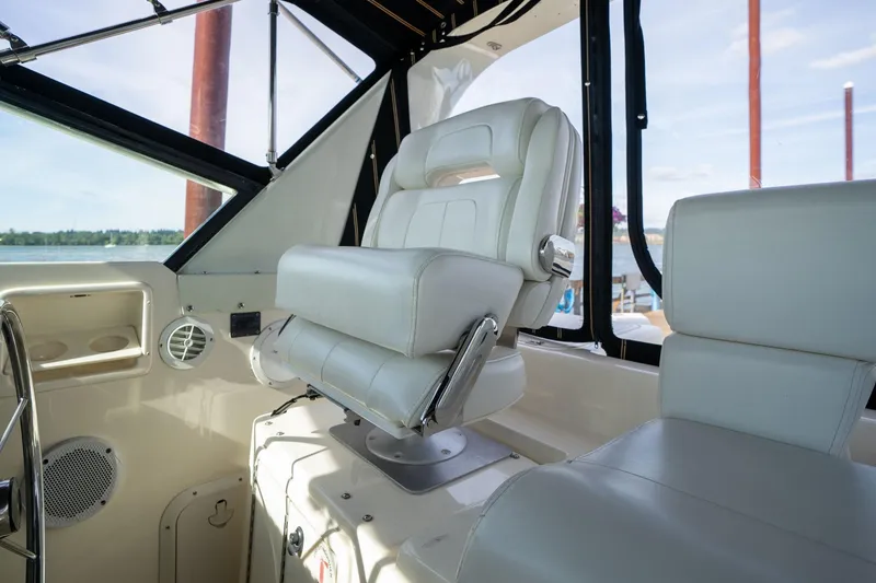 Slide: The Image of Captain's chair in 1998 Tiara Yachts 3500 Express cockpit, overlooking serene waters. - 38