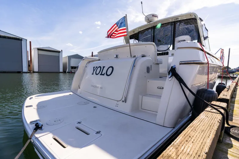 Slide: The Image of 1998 Tiara Yachts 3500 Express docked, displaying "YOLO" and American flag. - 4