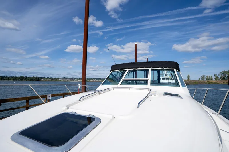 Slide: The Image of 1998 Tiara Yachts 3500 Express docked, showcasing sleek design under a clear blue sky. - 49