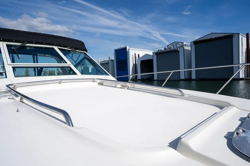 Slide: The Image of 1998 Tiara Yachts 3500 Express docked near boat houses under blue sky. - 50