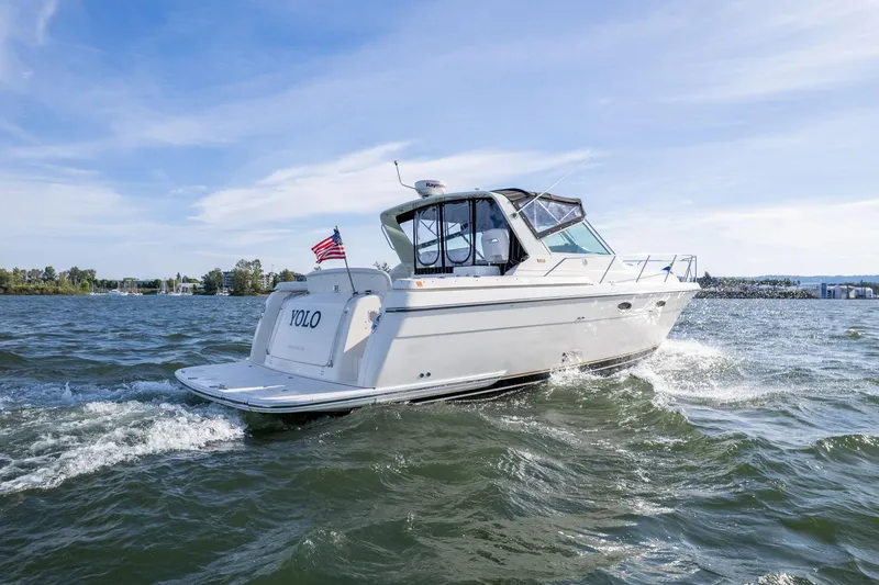 Slide: The Image of 1998 Tiara Yachts 3500 Express cruising on open water under a clear sky. - 56
