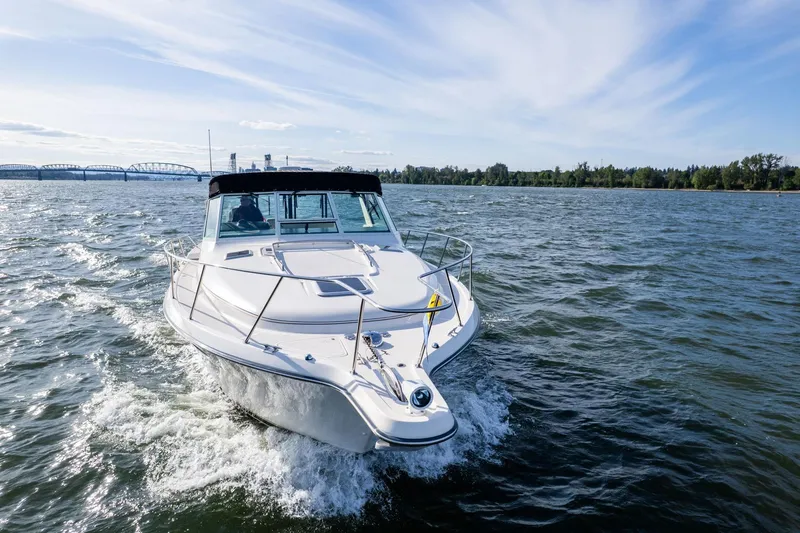 Slide: The Image of 1998 Tiara Yachts 3500 Express cruising on a scenic waterway under a clear sky. - 57