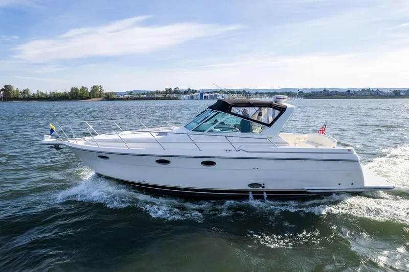 Slide: The Image of 1998 Tiara Yachts 3500 Express cruising on open water under clear skies. - 59