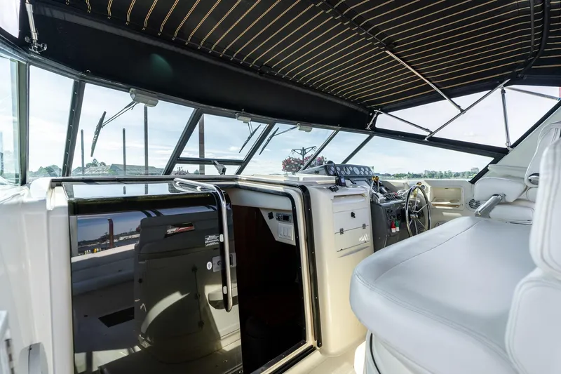 Slide: The Image of 1998 Tiara Yachts 3500 Express cockpit with steering wheel and seating under canopy. - 6