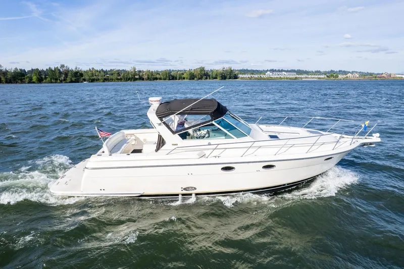 Slide: The Image of 1998 Tiara Yachts 3500 Express cruising on a scenic lake. - 61