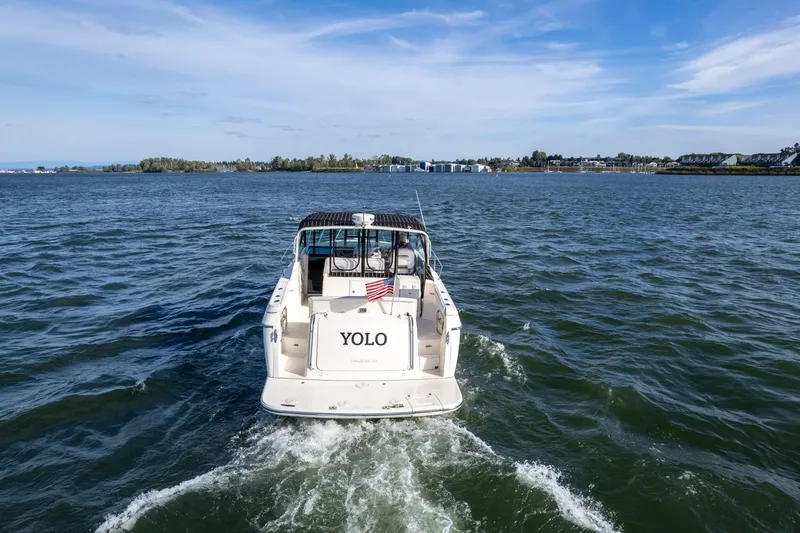 Slide: The Image of 1998 Tiara Yachts 3500 Express cruising on open water under a clear blue sky. - 62