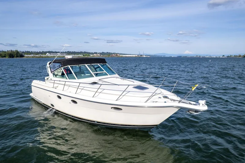 Slide: The Image of 1998 Tiara Yachts 3500 Express cruising on open water under a clear sky. - 63