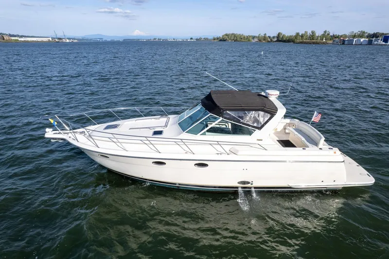Slide: The Image of 1998 Tiara Yachts 3500 Express cruising on open water under clear skies. - 64
