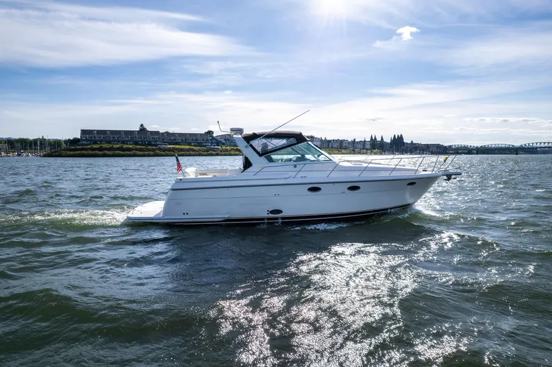 Slide: The Image of 1998 Tiara Yachts 3500 Express cruising on a sunny day with scenic background. - 65
