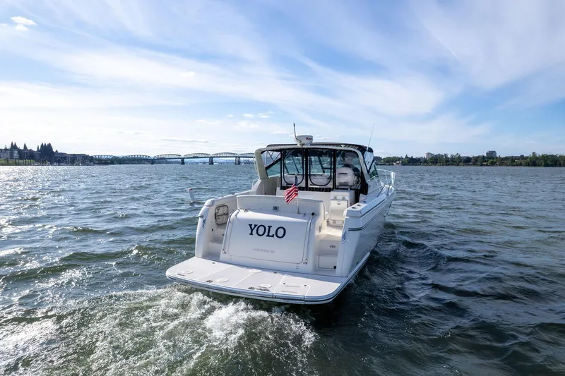 Slide: The Image of 1998 Tiara Yachts 3500 Express cruising on a scenic waterway under a clear blue sky. - 66