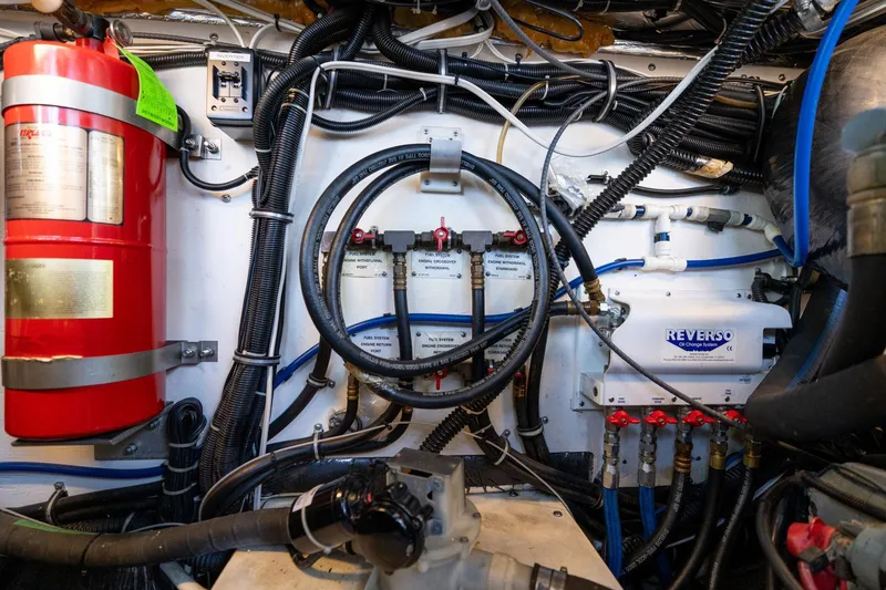 Slide: The Image of Engine room of a 1998 Tiara Yachts 3500 Express, featuring wiring and Reverso oil system. - 72