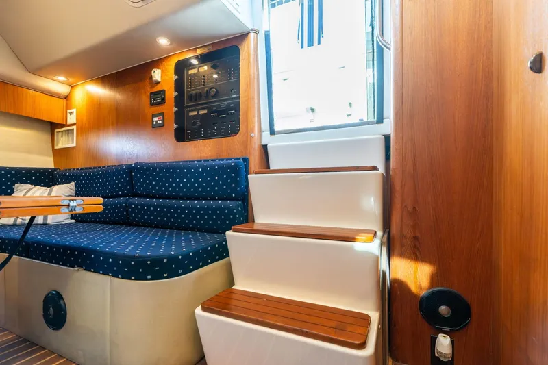 Slide: The Image of Interior of 1998 Tiara Yachts 3500 Express with blue seating and wooden accents. - 8