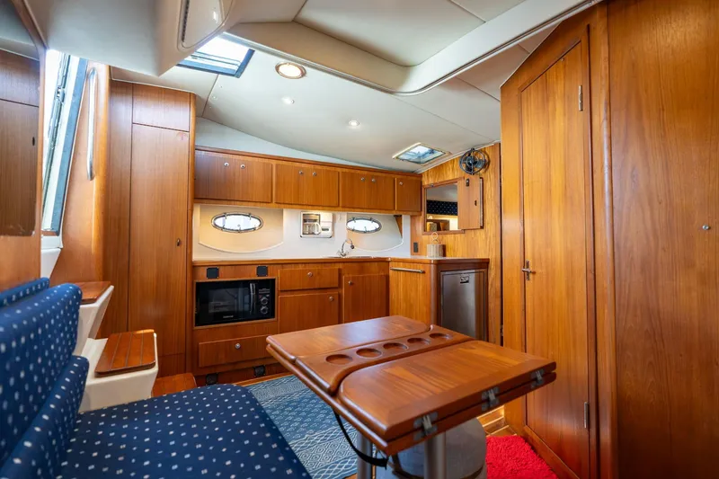 Slide: The Image of Interior of a 1998 Tiara Yachts 3500 Express, featuring wood cabinetry and seating. - 9