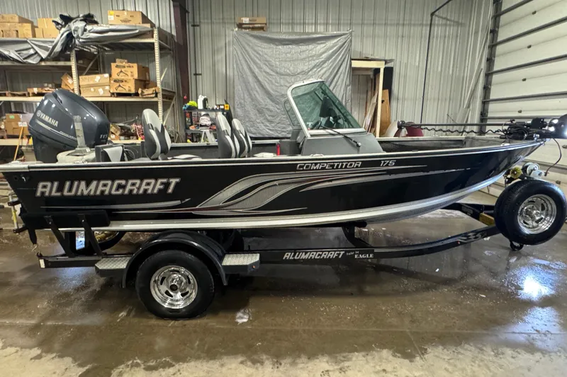 The Image of 2013 Alumacraft Competitor 175 Sport boat on trailer in a garage setting. - 0