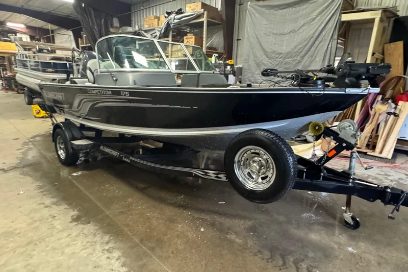 Slide: The Image of 2013 Alumacraft Competitor 175 Sport boat on trailer in a warehouse setting. - 2