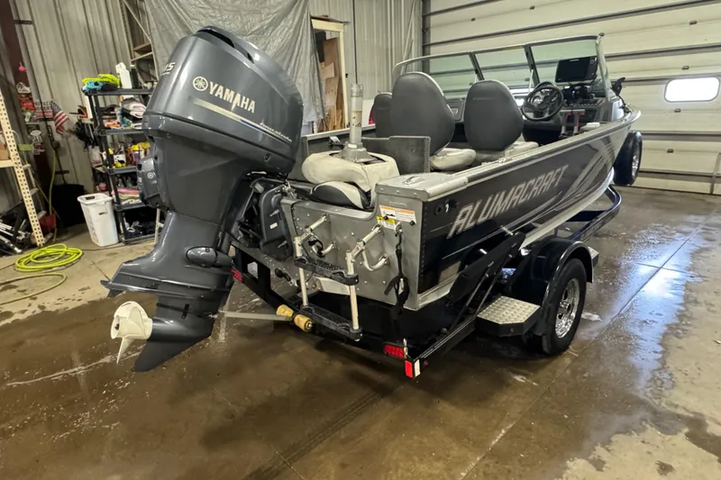 Slide: The Image of 2013 Alumacraft Competitor 175 Sport boat with Yamaha outboard motor in a garage. - 3