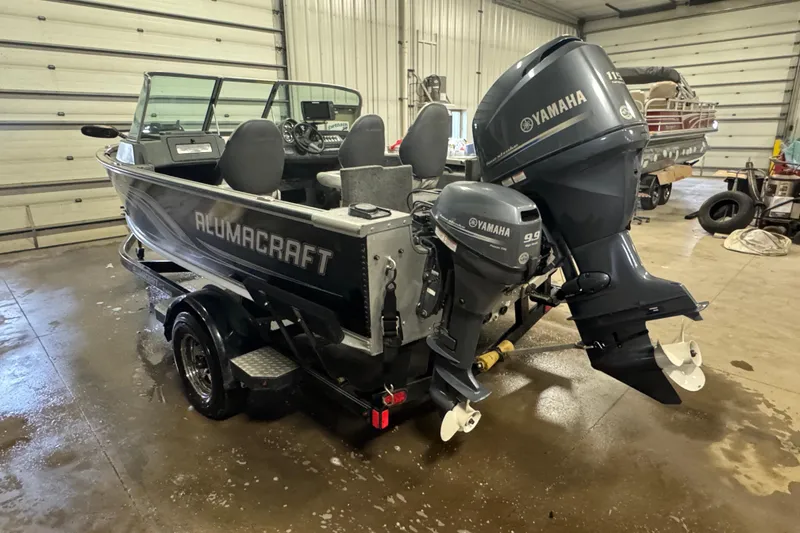 Slide: The Image of 2013 Alumacraft Competitor 175 Sport boat with Yamaha outboard motors in a garage setting. - 4