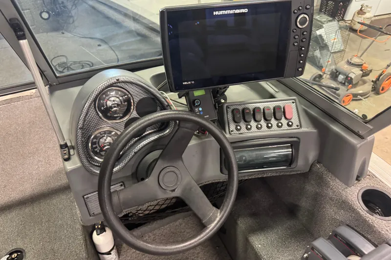 Slide: The Image of 2013 Alumacraft Competitor 175 Sport dashboard with steering wheel and Humminbird Helix 10 fish finder. - 7