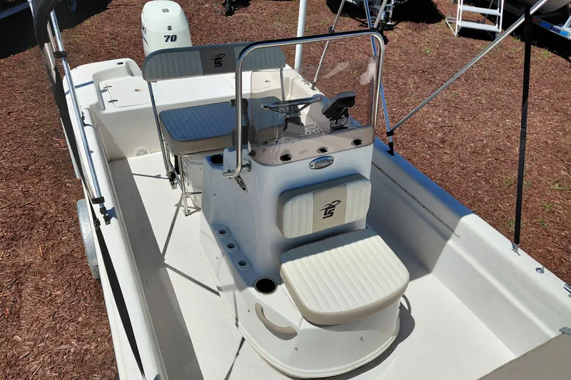 Slide: The Image of 2017 Carolina Skiff 18 JVX CC boat interior with seating and console, parked on mulch. - 14
