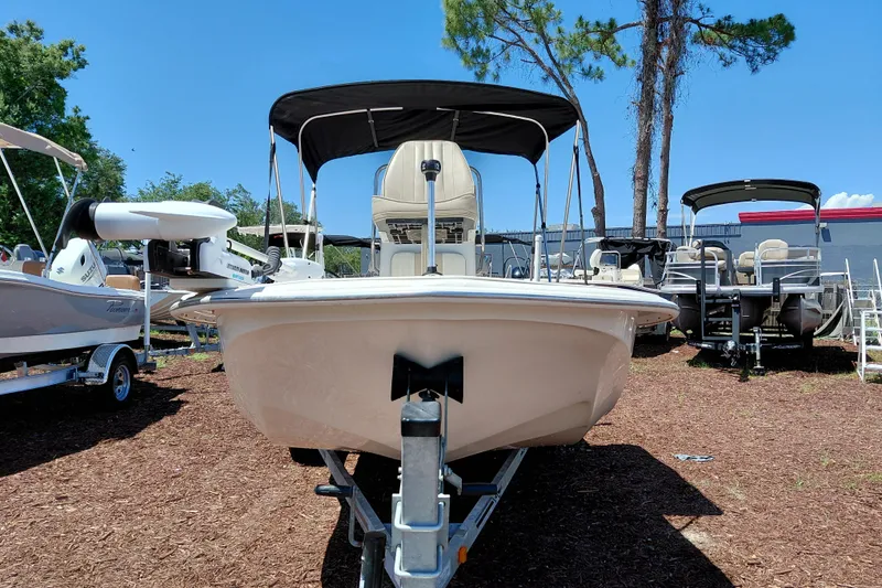 Slide: The Image of 2017 Carolina Skiff 18 JVX CC boat on trailer, displayed outdoors under clear blue sky. - 2