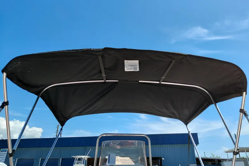 Slide: The Image of 2017 Carolina Skiff 18 JVX CC boat with black bimini top under clear blue sky. - 26