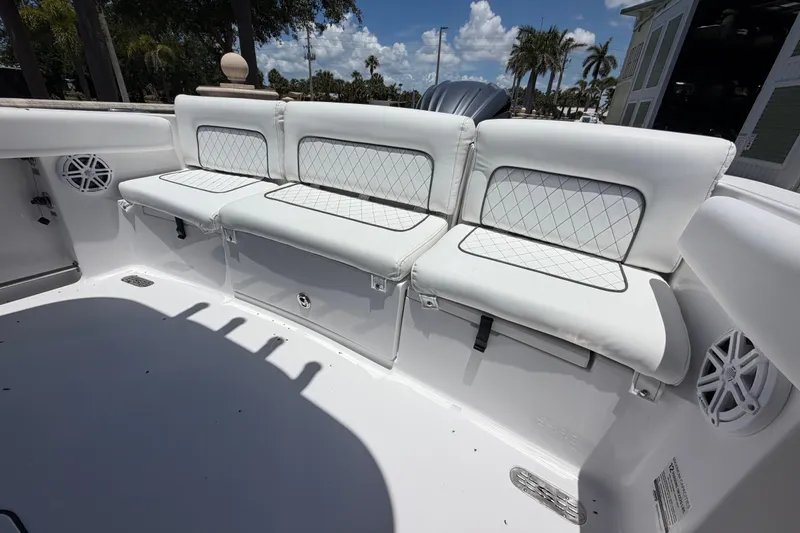 Slide: The Image of 2022 Sportsman Heritage 231 Center Console boat with white cushioned seating and speakers. - 11