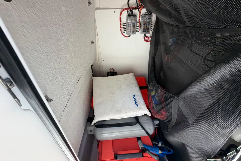 Slide: The Image of Storage compartment of 2022 Sportsman Heritage 231 Center Console with safety equipment and wiring. - 18