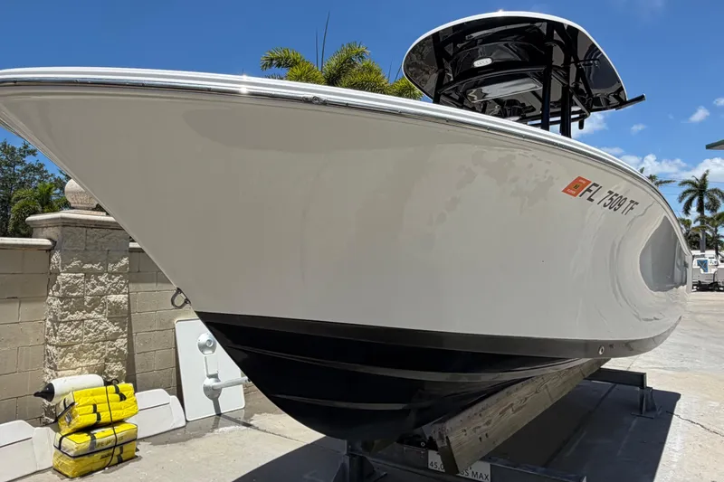 Slide: The Image of 2022 Sportsman Heritage 231 Center Console boat on trailer, sunny day, palm trees in background. - 4