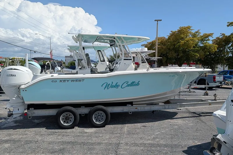 Slide: The Image of 2025 Key West 260 Center Console boat on trailer, featuring Yamaha engines, under a clear sky. - 1