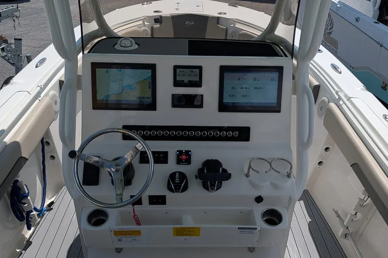 Slide: The Image of 2025 Key West 260 Center Console boat dashboard with navigation screens and steering wheel. - 15