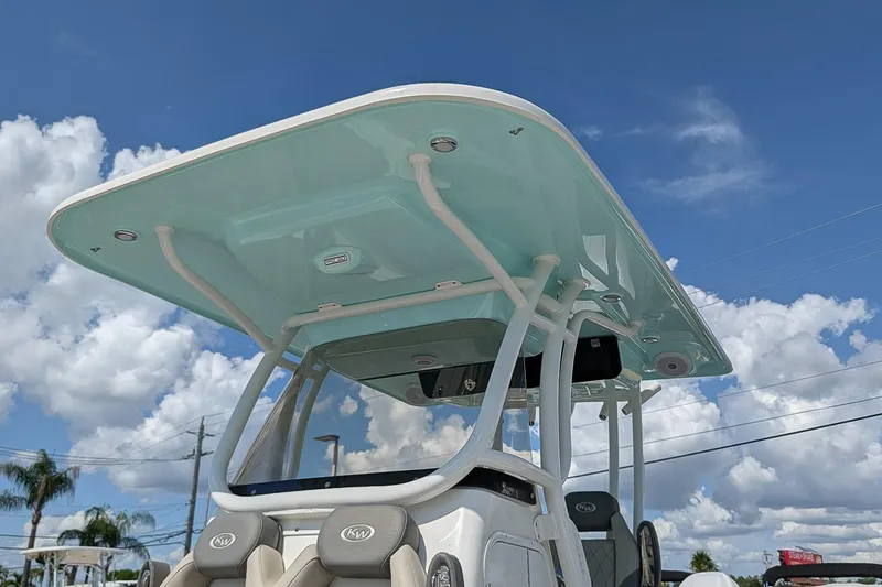 Slide: The Image of 2025 Key West 260 Center Console boat with sleek T-top under a clear blue sky. - 24
