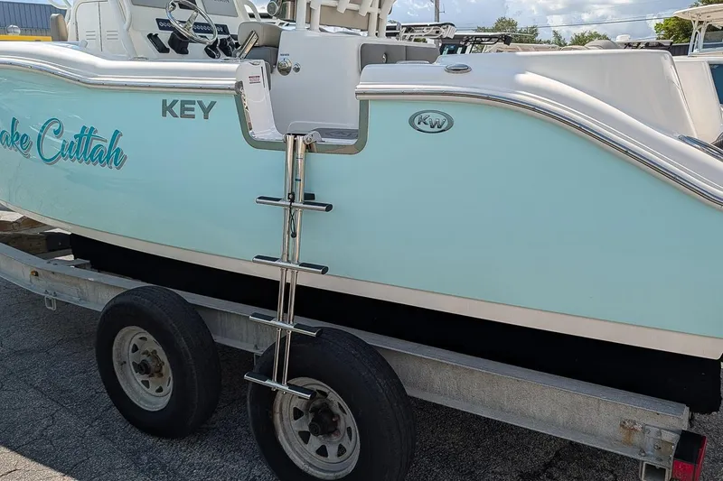 Slide: The Image of 2025 Key West 260 Center Console boat on trailer, featuring sleek design and ladder. - 8