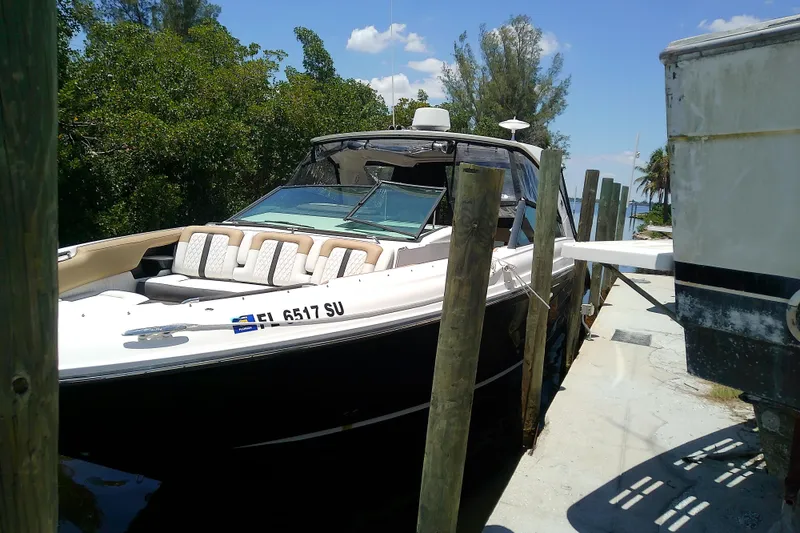 The Image of 2019 Sea Ray SLX 400 Outboard docked, surrounded by lush greenery and clear skies. - 0