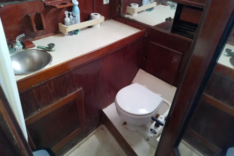 Slide: The Image of 2019 Sea Ray SLX 400 Outboard bathroom with sink, toilet, and wooden cabinetry. - 16