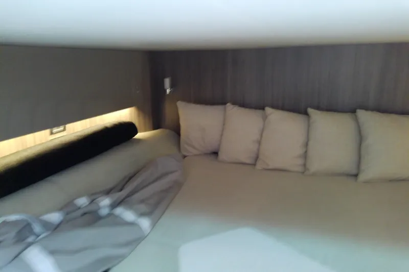 Slide: The Image of Cozy cabin interior of 2019 Sea Ray SLX 400 Outboard with cushions and bedding. - 49