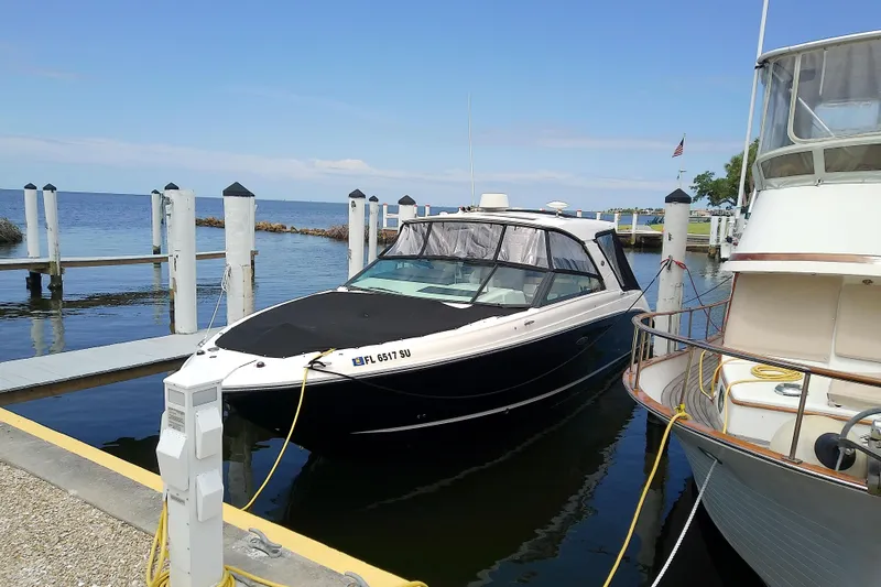 Slide: The Image of 2019 Sea Ray SLX 400 Outboard docked at marina with clear blue sky. - 56