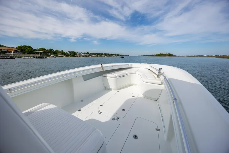Slide: The Image of 2013 Yellowfin 32 Offshore boat on calm water, featuring spacious seating and clear skies. - 11