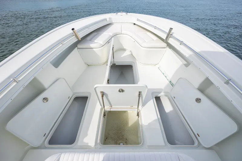 Slide: The Image of 2013 Yellowfin 32 Offshore boat interior with open storage compartments on calm water. - 13