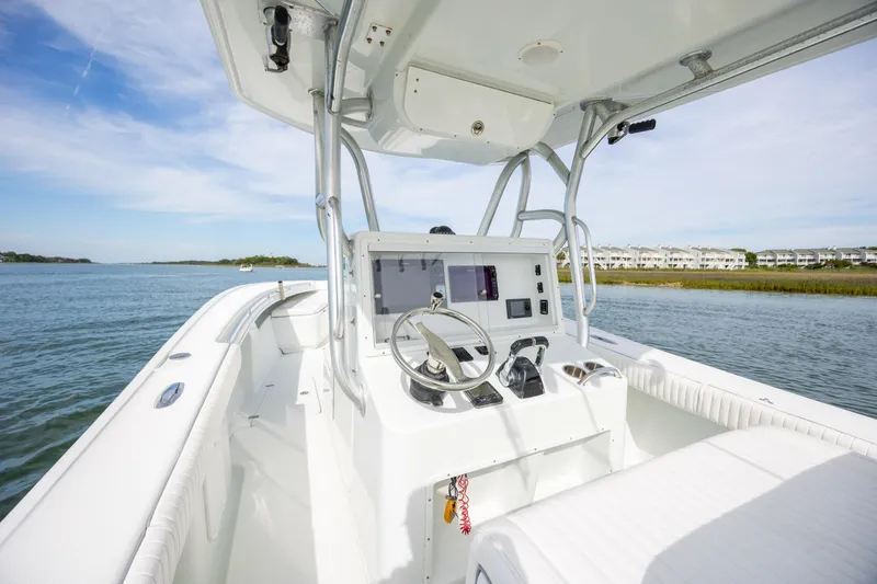 Slide: The Image of 2013 Yellowfin 32 Offshore boat interior with steering console on calm water. - 15