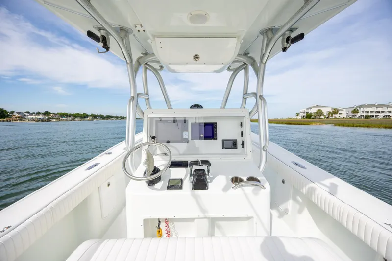 Slide: The Image of 2013 Yellowfin 32 Offshore boat cockpit with steering wheel and navigation equipment. - 16