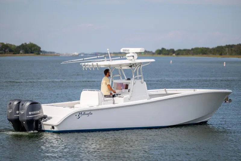 Slide: The Image of 2013 Yellowfin 32 Offshore boat cruising on calm waters with dual Yamaha engines. - 2