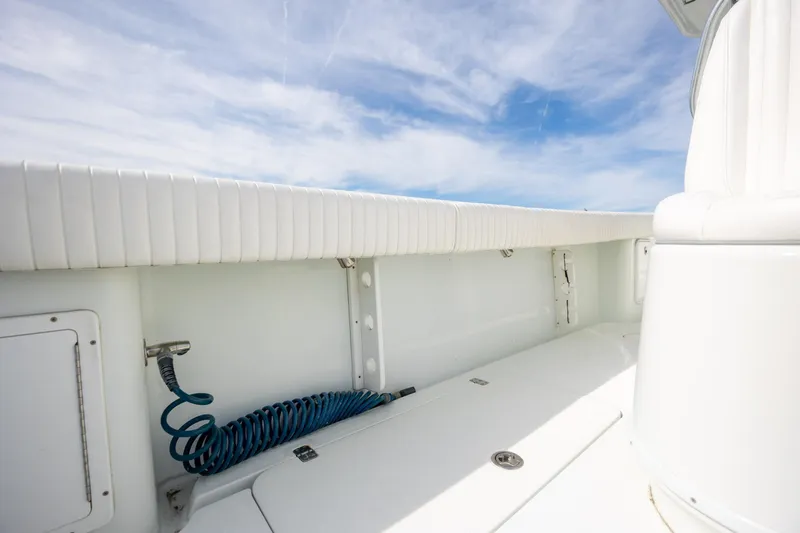 Slide: The Image of 2013 Yellowfin 32 Offshore boat interior with white seating and coiled blue hose. - 21
