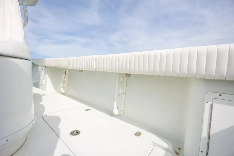 Slide: The Image of 2013 Yellowfin 32 Offshore boat interior with white cushioned seating and clear sky. - 22